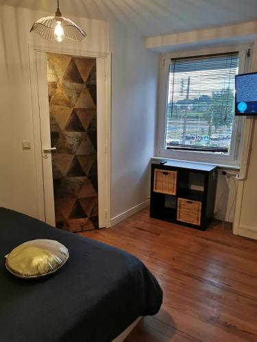 Schlafzimmer mit einem Bett, einem Fenster und einem TV in der Unterkunft chambres randonneurs in Plestin-les-Grèves
