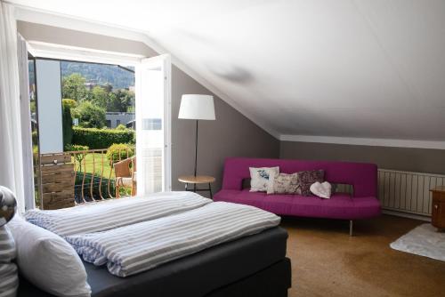 1 dormitorio con cama y sofá púrpura en Haus Bregenz Apartment Festspiele, en Lochau