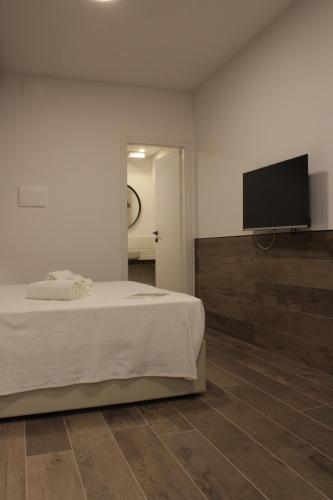 a bedroom with a bed and a flat screen tv at Venere B&B Castelmola in Castelmola