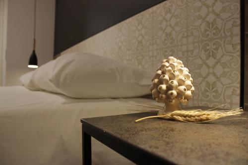 a pineapple statue on a table next to a bed at Venere B&B Castelmola in Castelmola