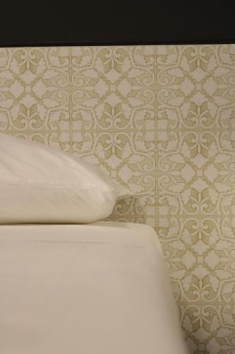 a bathroom with a toilet and a wall with a wallpaper at Venere B&B Castelmola in Castelmola