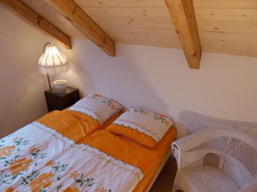 a bedroom with a bed and a lamp and a chair at Haus am See in Därligen