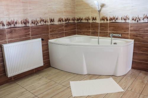 a bathroom with a white tub and a radiator at Forest Luxury Apartman in Dorogháza