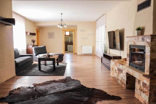 a living room with a couch and a fireplace at Forest Luxury Apartman in Dorogháza