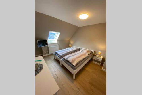 a bedroom with a bed and a television in it at Ferienwohnung Zwischen Eider u. Elbe in Eddelak