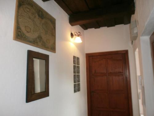 a hallway with a wooden door and a mirror at Ninszianna Apartman in Hegyhátszentjakab