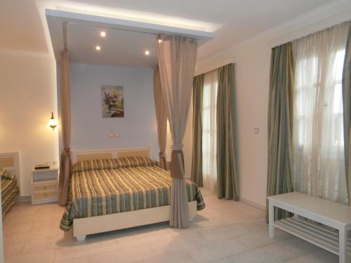 a bedroom with a bed and a large mirror at Katerina Hotel in Agios Prokopios