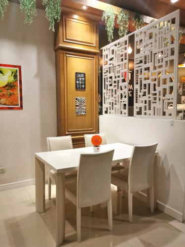 a dining room with a white table and chairs at Patong Princess in Patong Beach