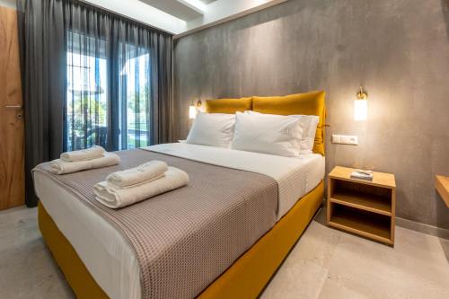 a bedroom with a large bed with towels on it at 3 DOORS VILLAS in Iraklitsa
