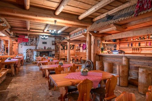 un restaurante con mesas y sillas de madera y un bar en Penzión Sova Ždiar, en Ždiar