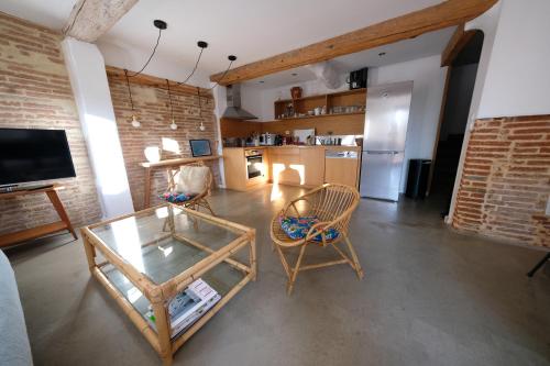 a living room with a table and chairs and a kitchen at Bastide le Petit Clos - les 2 Gîtes in Perpignan