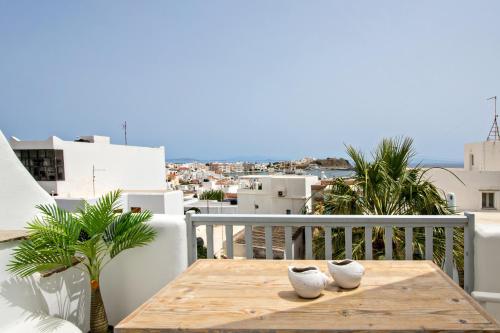 a table on a balcony with a view of the city at Onar Hotel & Suites in Tinos Town
