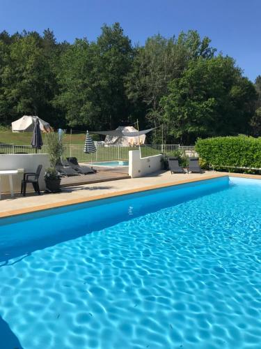 - une piscine d'eau bleue dans la cour dans l'établissement Dordogne Glamping, à Bouzic