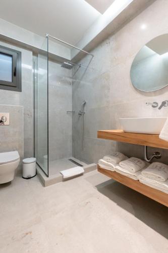 a bathroom with a glass shower and a sink at 3 DOORS VILLAS in Iraklitsa