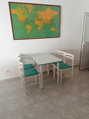 a table and chairs with a map on the wall at La Thérésita in Six-Fours-les-Plages