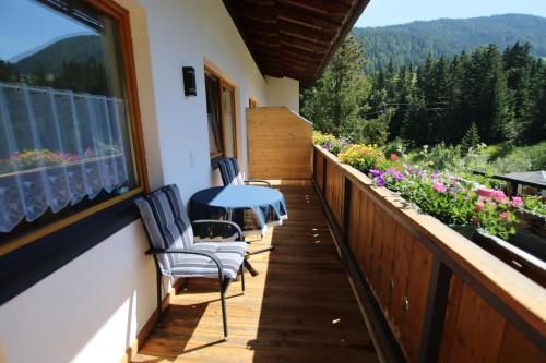 a balcony of a house with a table and chairs at Haus Enzian Apartments in Kartitsch