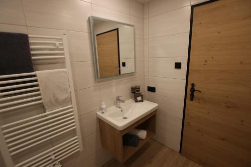 a bathroom with a sink and a mirror at Haus Enzian Apartments in Kartitsch