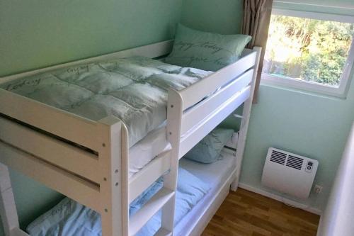 a white bunk bed in a room with a window at Ferienhaus Green Garden Berlin - Welcome to Berlin in Berlin