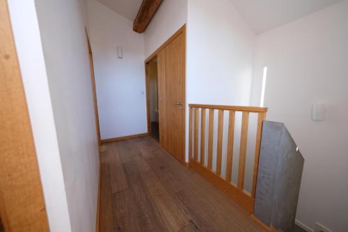 a hallway with a wooden staircase and a wooden door at Bastide le Petit Clos - les 2 Gîtes in Perpignan