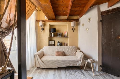 a living room with a white couch in a room at Opera Suites - Le mille e una notte in Calcata