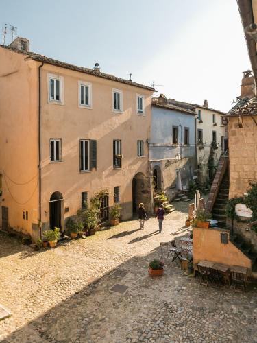 a couple of people walking down a street at Opera Suites - Le mille e una notte in Calcata