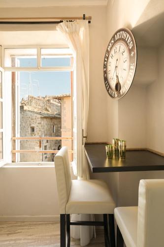 a clock on a wall next to a table and a window at Opera Suites - Le mille e una notte in Calcata
