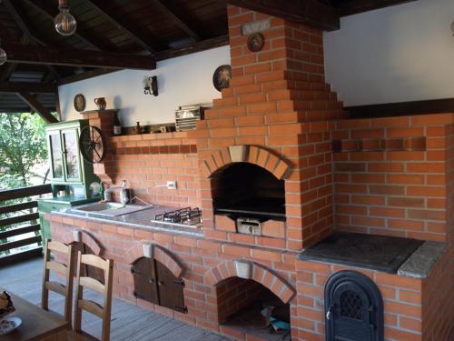 een bakstenen oven in een keuken met een fornuis bij Casa Albinuța in Călimăneşti