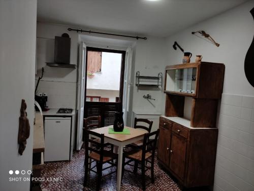 cocina con mesa y sillas en una habitación en UNA CASA DEL BORGO MEDIEVALE a HOUSE IN MEDIEVAL VILLAGE, en Gessopalena