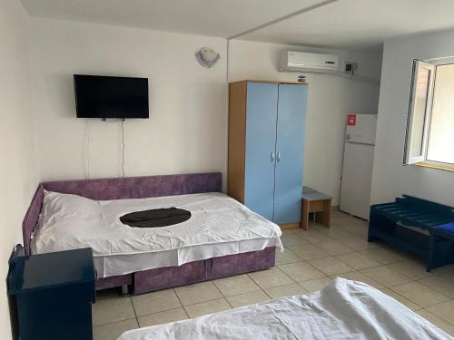 a bedroom with a bed and a tv on the wall at Casa Poseidon in Costinesti