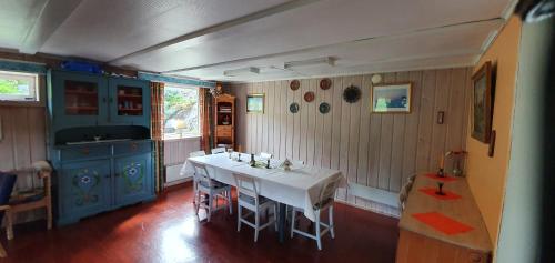 cocina con mesa blanca y armarios azules en Røisheim en Tyinkrysset