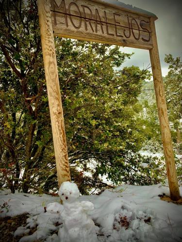 a teddy bear sitting under a sign in the snow at Casa Tatisita Family in Segura de la Sierra