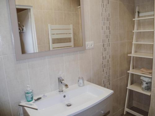 bagno con lavandino, specchio e scaffali di LA LAUJÈRE Chambres d'hôtes ROMANCE a La Caillère