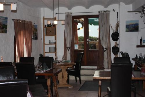 a dining room with a table and chairs and a door at L'Almàssera Casa Rural & Restaurant in Margarida