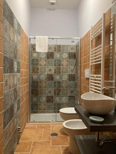 y baño con 2 aseos, lavamanos y ducha. en Agriturismo Tenuta della Madama, en Venticano