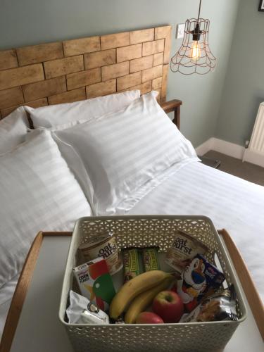 a basket of food sitting on top of a bed at Rooms at Martha Jones in Pwllheli