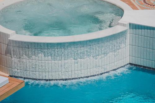 a large swimming pool with blue water at Zeus Village Resort - Adults Only in Kato Daratso