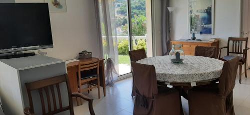 un salon avec une table à manger et une télévision dans l'établissement Maison Margot, à Vallauris