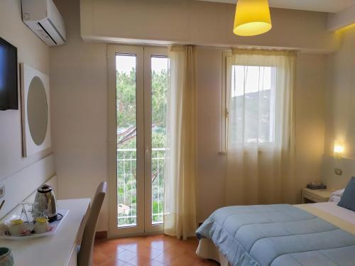 a bedroom with a bed and a table and a window at Hotel Villa Fiorita in Sorrento