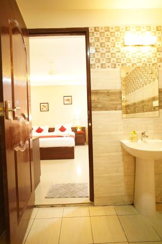 a bathroom with a shower and a sink and a bed at North Centre in Cochin