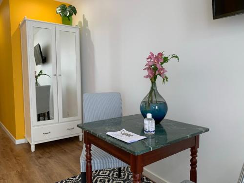 a vase of flowers on a table with a cabinet at Central - São Pedro Boutique in Funchal