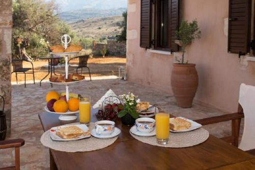 una mesa con platos de comida y jugo de naranja en Iliopetra Villa, en Beritianá
