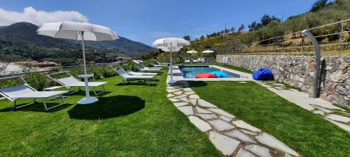 ein Pool mit Stühlen und Sonnenschirmen in einem Hof in der Unterkunft ARIA Design B&B Levanto in Levanto