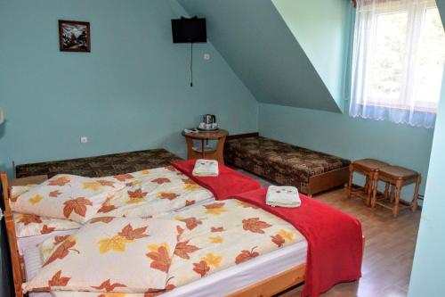 Zadwórze的住宿－優加娜扎酒店，一间卧室配有一张带红色毯子的床