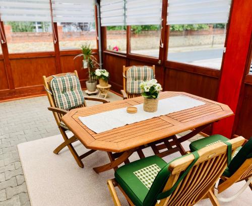 - une table et des chaises en bois sur une terrasse couverte dans l'établissement Ferienwohnung Alte Quickbox, à Thale