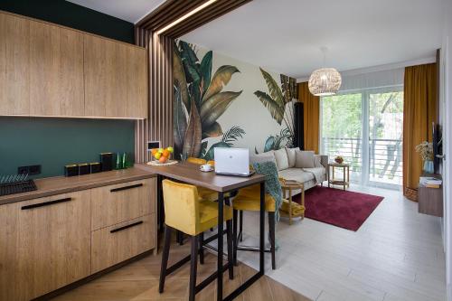 a kitchen with a table with a laptop on it at W&K Apartments - Energy Suite - Faktura VAT, Parking in Koszalin