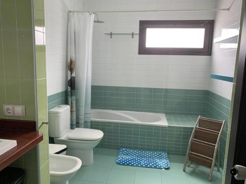 a bathroom with a toilet a sink and a bath tub at Habitaciones tía Ela in Yaiza