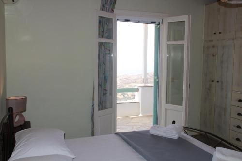 a bedroom with a bed and a door to a balcony at Laurel house in Triandáros