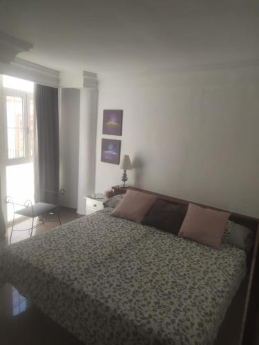 a bedroom with a bed and a chair and a window at MIRADOR del BALCON DE EUROPA 1A - Nerja in Nerja
