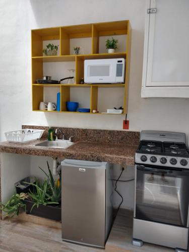 a kitchen with a stove and a sink at Casa Esencia in Cozumel