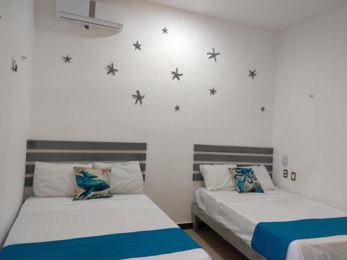two beds in a room with stars on the wall at Casa Esencia in Cozumel